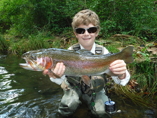 Tradd Little holding a large Arkansas rainbow trout.